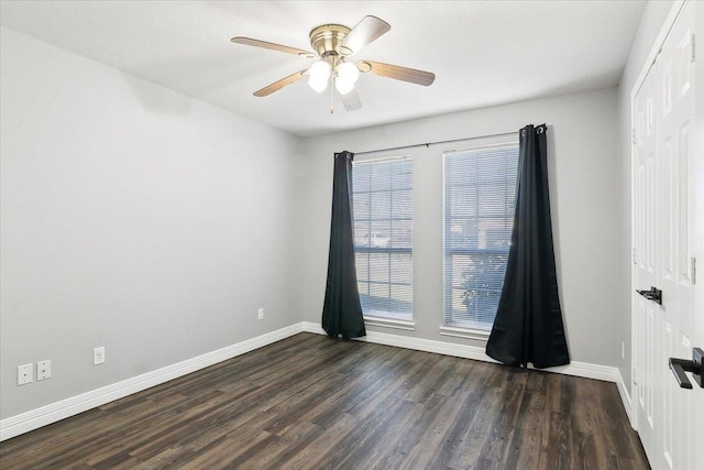 empty room featuring ceiling fan and dark hardwood / wood-style flooring