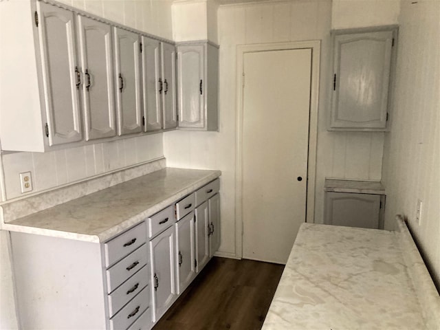 4701 Redbird St, Port Arthur, TX 77642 - kitchen with dark wood-type flooring, light countertops, decorative backsplash, and white cabinetry