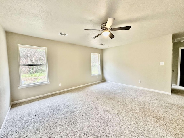 carpeted spare room featuring ceiling fan and a textured ceiling