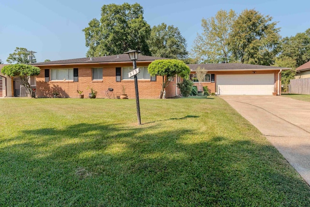 ranch-style home with brick siding, an attached garage, concrete driveway, and a front lawn