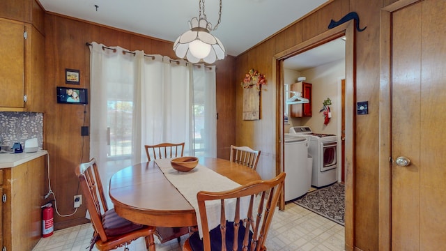 dining area with wooden walls, light floors, and washer and dryer