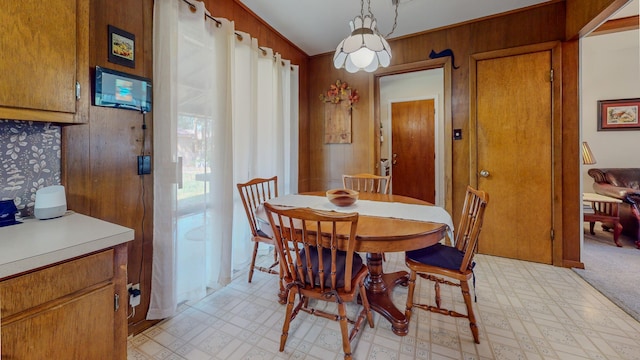 dining area with light floors and wood walls