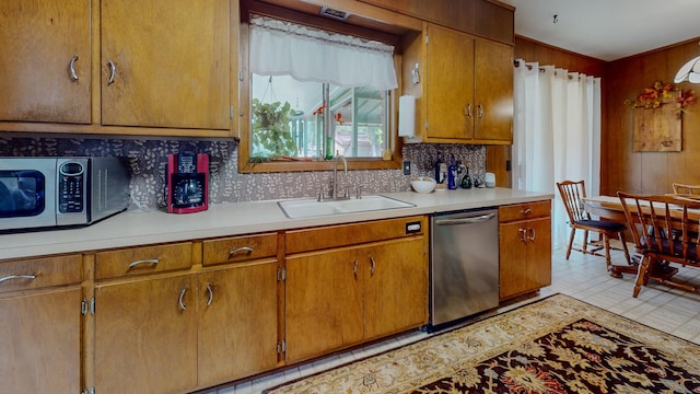 kitchen with a sink, stainless steel appliances, backsplash, and light countertops