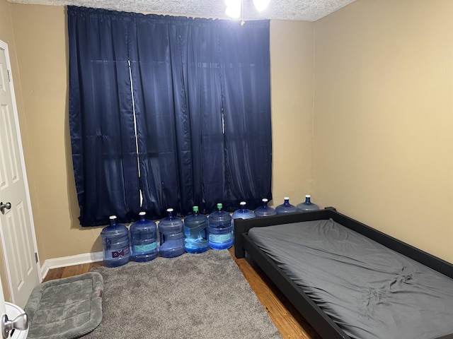 3720 Austin St, Beaumont, TX 77706 - bedroom with wood finished floors, a textured ceiling, and baseboards