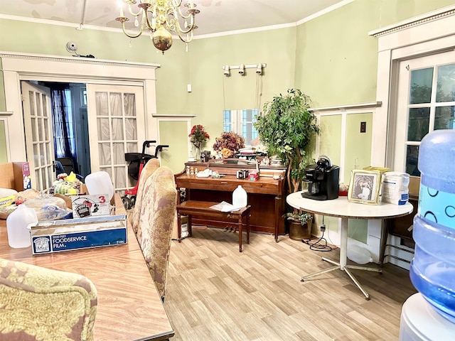 interior space featuring french doors, hardwood / wood-style flooring, an inviting chandelier, and crown molding