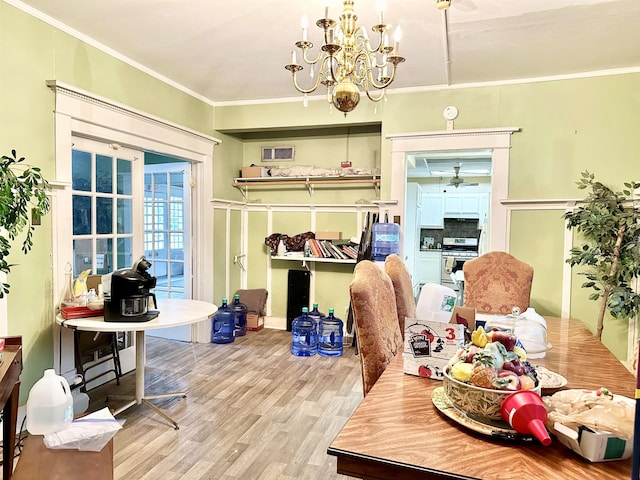 dining area with ceiling fan with notable chandelier, light hardwood / wood-style floors, and crown molding