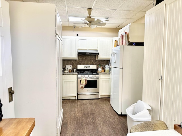 kitchen featuring white cabinetry, stainless steel gas stove, a drop ceiling, white refrigerator, and decorative backsplash