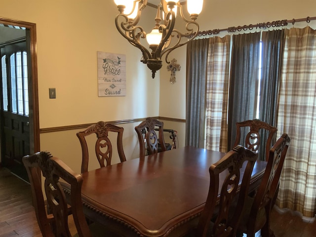 dining area with hardwood / wood-style floors and a notable chandelier