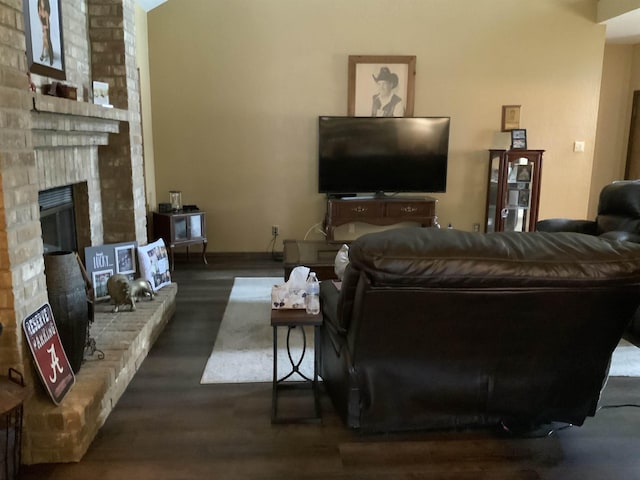 living room with a fireplace and dark wood-type flooring