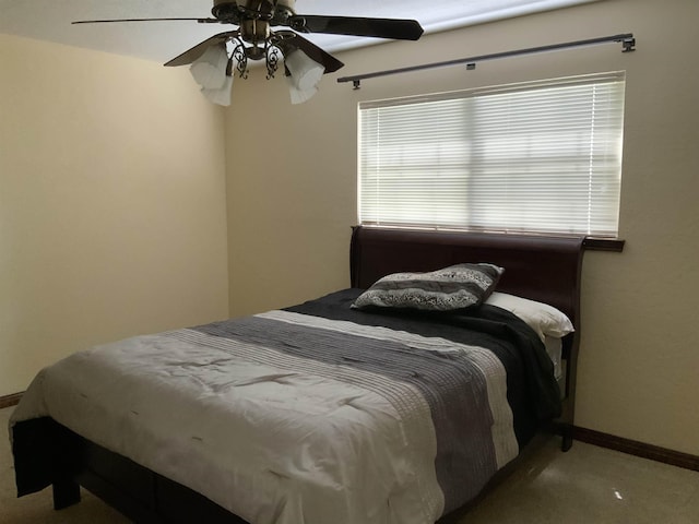 carpeted bedroom featuring multiple windows and ceiling fan