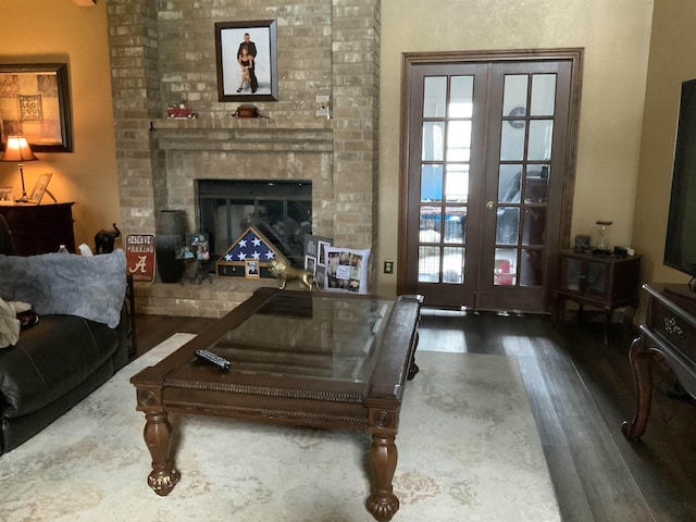 living room with a fireplace, french doors, and dark hardwood / wood-style floors