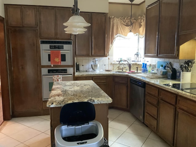 kitchen featuring light stone countertops, decorative backsplash, stainless steel dishwasher, sink, and pendant lighting