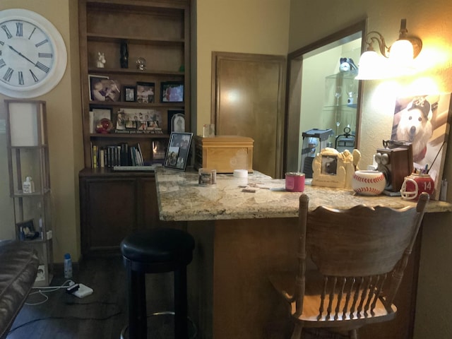 bar with built in shelves and light stone countertops