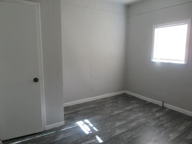 empty room with dark hardwood / wood-style flooring