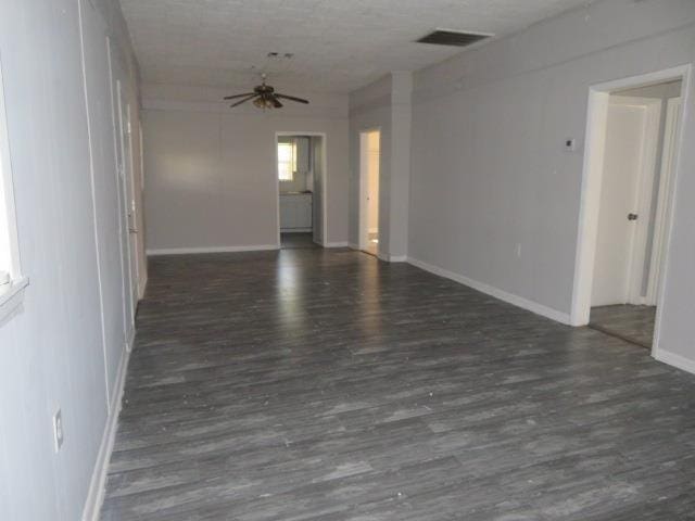 empty room with ceiling fan and dark hardwood / wood-style flooring