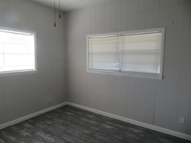 empty room with dark hardwood / wood-style flooring