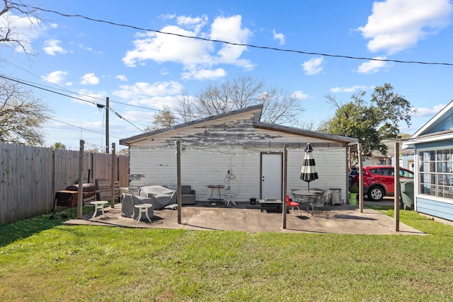 rear view of property featuring a yard, a patio, and fence