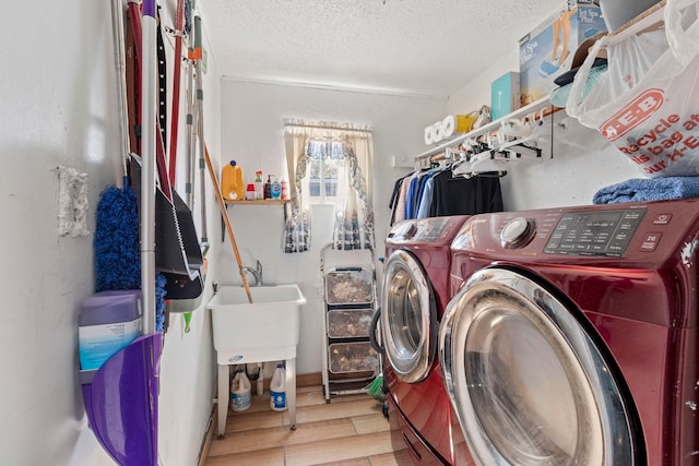 laundry room featuring laundry area, a textured ceiling, separate washer and dryer, and wood finished floors