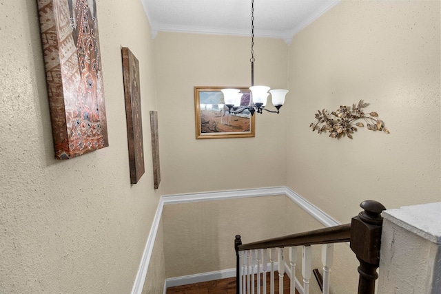 staircase with baseboards, ornamental molding, wood finished floors, and a notable chandelier