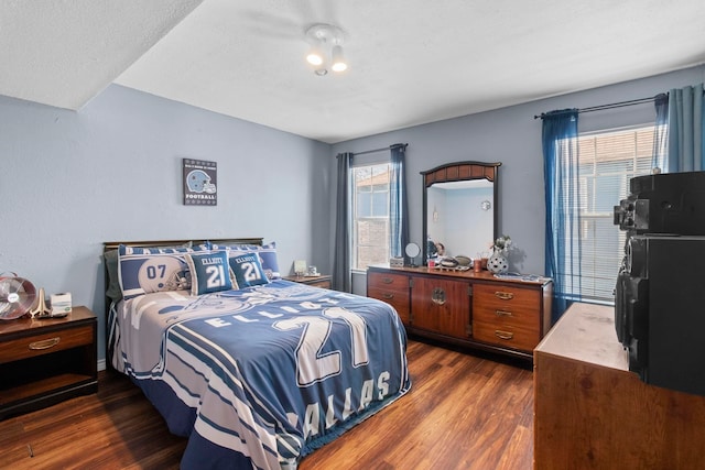 bedroom featuring dark wood-style floors, multiple windows, and a textured ceiling