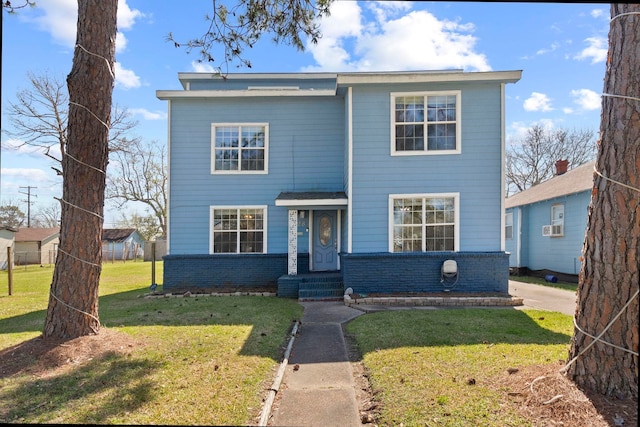 traditional home with a front yard and brick siding