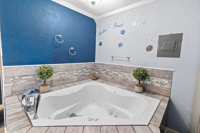 bathroom featuring a whirlpool tub, electric panel, a textured ceiling, and a textured wall