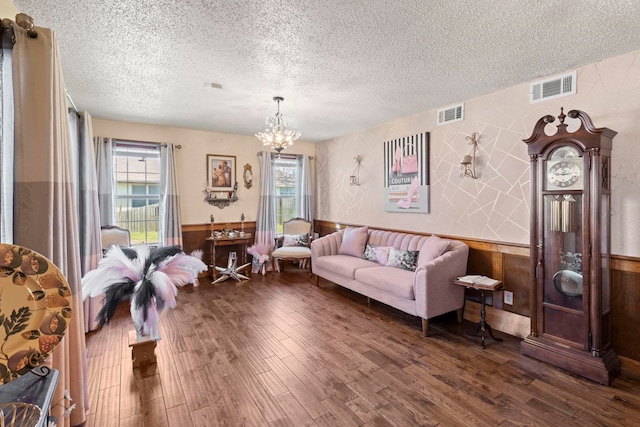 sitting room with a wainscoted wall, visible vents, and dark wood-style flooring