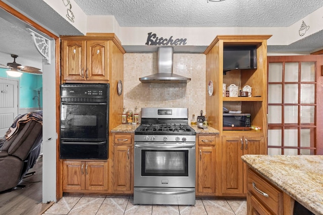 kitchen with light stone countertops, wall chimney range hood, stainless steel appliances, and a warming drawer