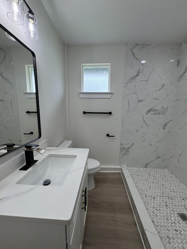 3022 S Drive, Groves, TX 77619 - bathroom featuring a marble finish shower, vanity, and wood finished floors