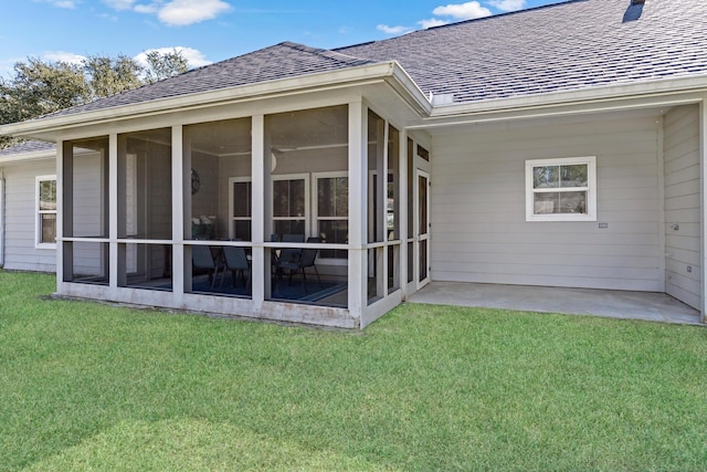 back of house featuring a yard, a patio area, and a sunroom