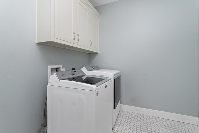 laundry room featuring cabinets and washer and clothes dryer