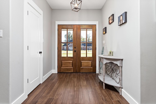 entryway featuring french doors, dark hardwood / wood-style floors, and a chandelier