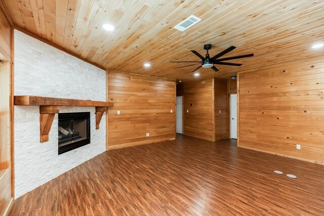 1905 Villa Rd, Kountze, TX 77625 - unfurnished living room featuring a fireplace, wood ceiling, wood finished floors, ceiling fan, and wooden walls