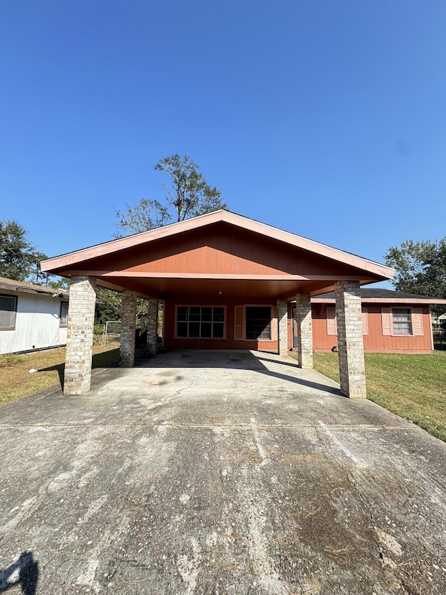 view of front of house with a front lawn and a carport