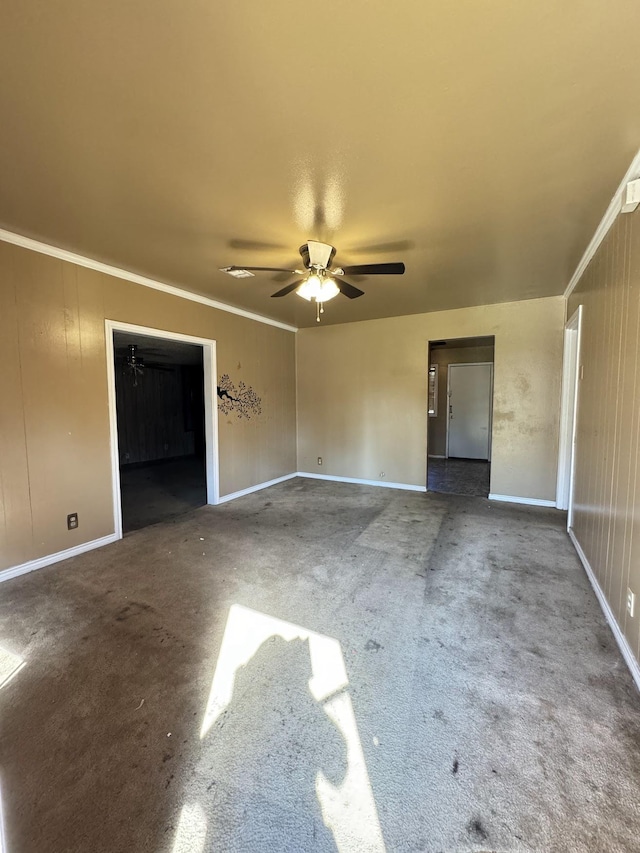 empty room featuring ceiling fan, carpet floors, and ornamental molding