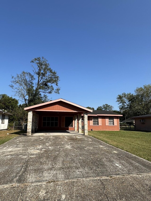 single story home with a front lawn and a carport