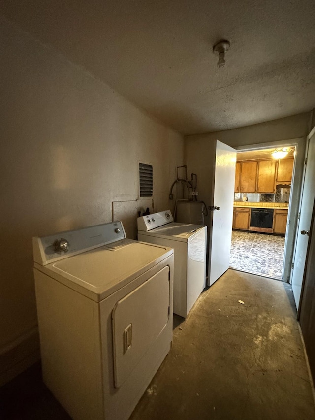 washroom with washer and clothes dryer and water heater