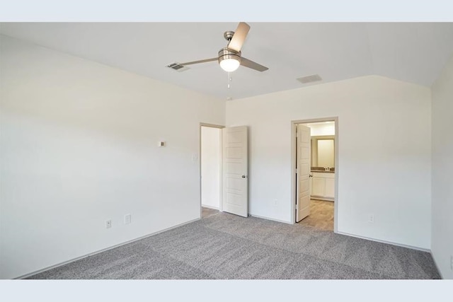 unfurnished bedroom featuring ceiling fan, light colored carpet, and vaulted ceiling