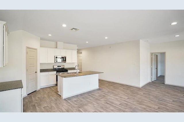 kitchen featuring stainless steel appliances, sink, light hardwood / wood-style flooring, white cabinets, and an island with sink