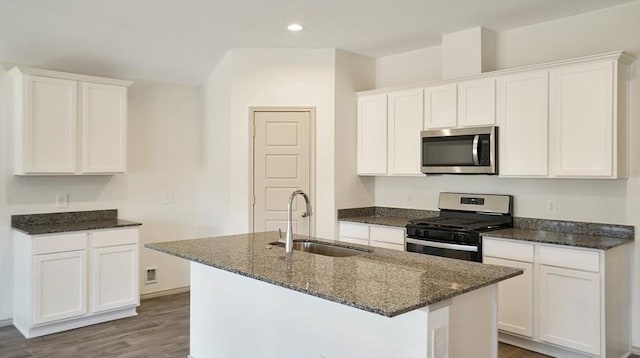 kitchen featuring hardwood / wood-style floors, a kitchen island with sink, white cabinets, sink, and appliances with stainless steel finishes