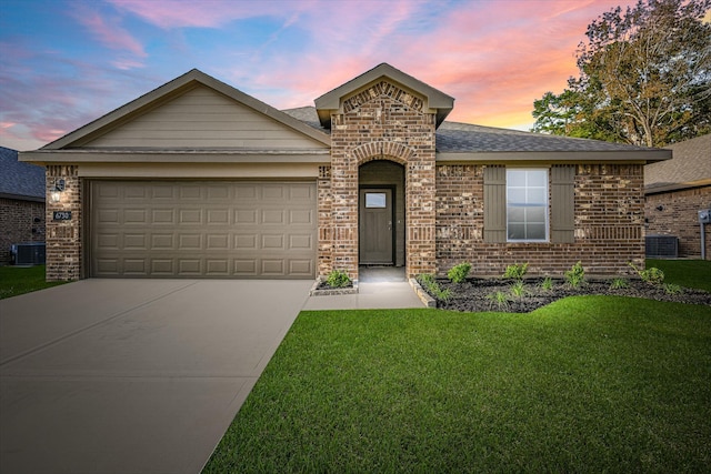 view of front of property with a lawn, cooling unit, and a garage