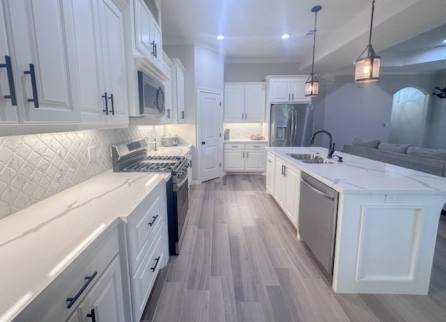 308 Long Leaf St, Silsbee, TX 77656 - kitchen featuring stainless steel appliances, a sink, decorative backsplash, white cabinetry, and ornamental molding