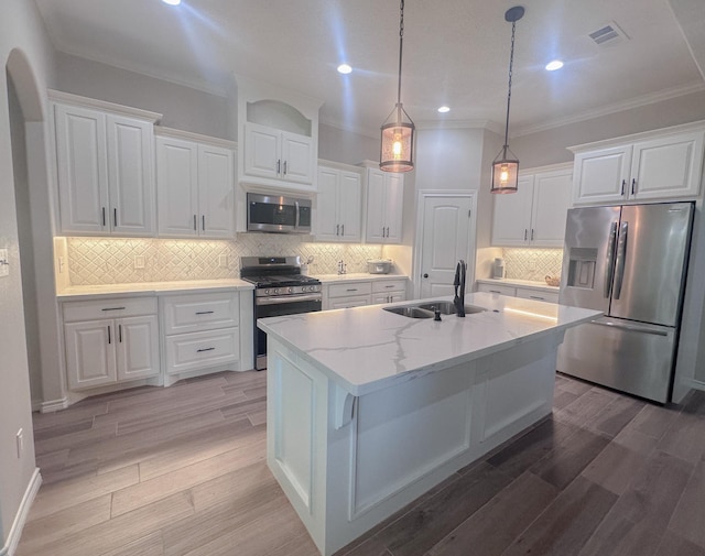 308 Long Leaf St, Silsbee, TX 77656 - kitchen featuring appliances with stainless steel finishes, a sink, white cabinets, ornamental molding, and light wood finished floors