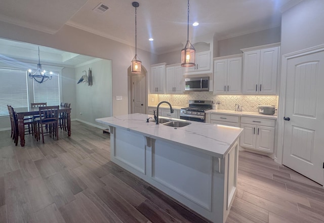 308 Long Leaf St, Silsbee, TX 77656 - kitchen featuring appliances with stainless steel finishes, a sink, a chandelier, white cabinetry, and crown molding