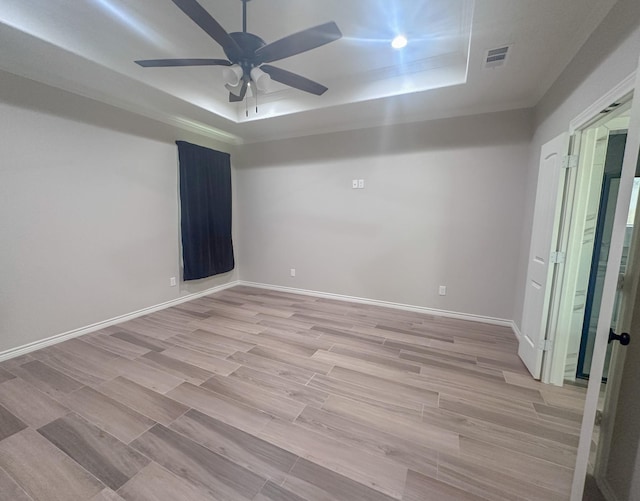 308 Long Leaf St, Silsbee, TX 77656 - spare room featuring a tray ceiling, light wood-style flooring, ceiling fan, and baseboards