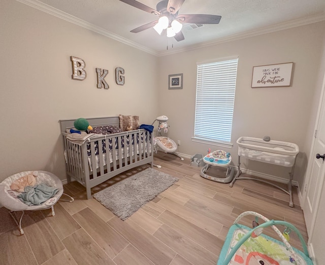 308 Long Leaf St, Silsbee, TX 77656 - bedroom featuring crown molding, wood finished floors, a nursery area, a ceiling fan, and baseboards