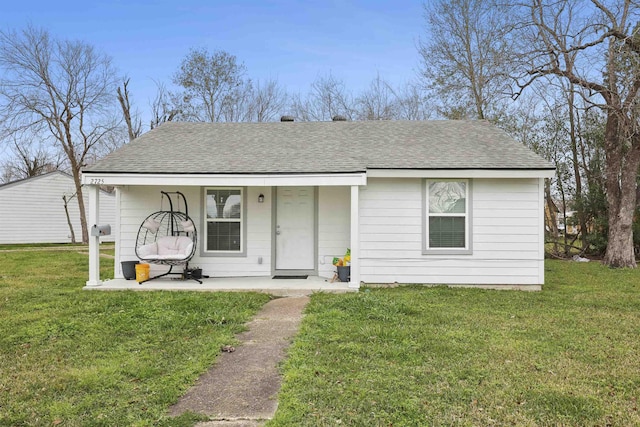 view of front of home featuring a shingled roof, a front yard, and a porch