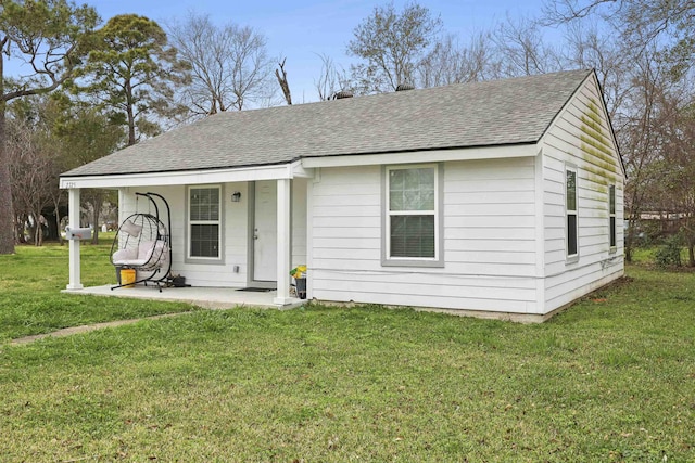 view of front of house with a front lawn and roof with shingles