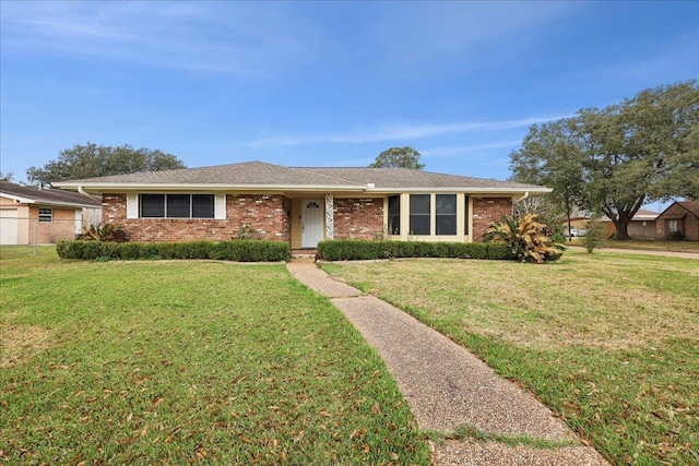 single story home with brick siding and a front yard