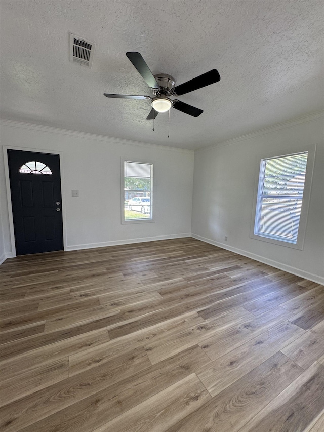 6250 Howe St, Groves, TX 77619 - foyer entrance featuring a textured ceiling, a ceiling fan, crown molding, and wood finished floors